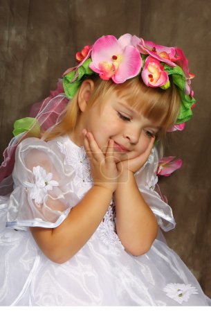 Triste fille dans une robe blanche et une couronne 