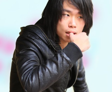 Réfléchi asiatique homme mordre ongles 