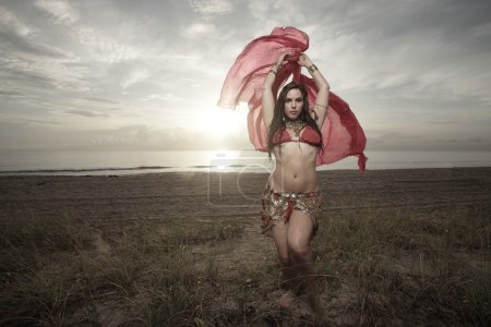 Femme dansant sur la plage au lever du soleil 